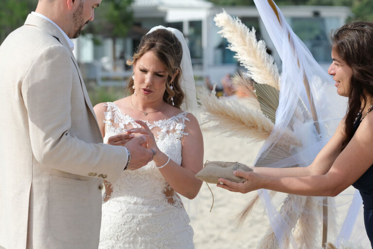 Jolanda-Melis-überreicht-die-Ringe-während-der-Trauungszeremonie,-Strandhochzeit---meer-sardinien-urlaub