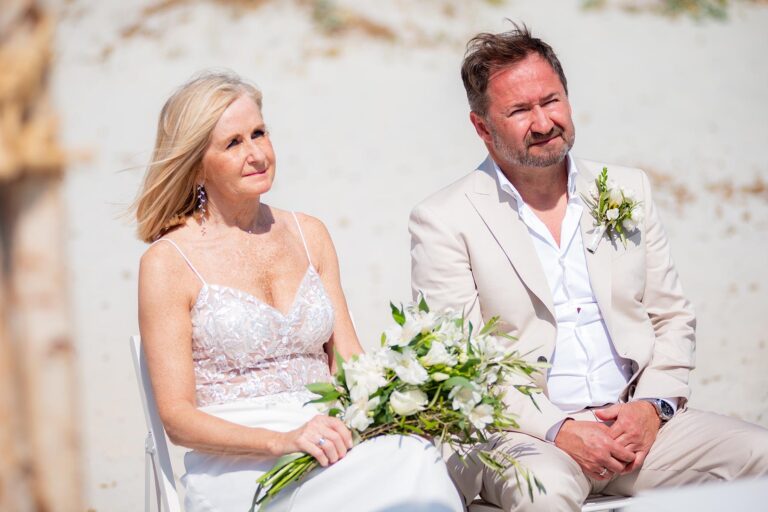 aufmerksam nimmt das Brautpaar die wichtigen Worte des Standesbeamten während der Strandhochzeit auf - meer sardinien urlaub