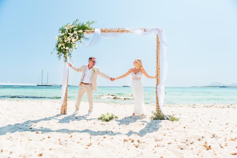 das Brautpaar unter dem Traubogen im Anschluss an die Strandhochzeit - meer sardinien urlaub