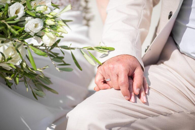 die verschlungenen Hände des Brautpaares während der Zeremonie der Strandhochzeit - meer sardinien urlaub