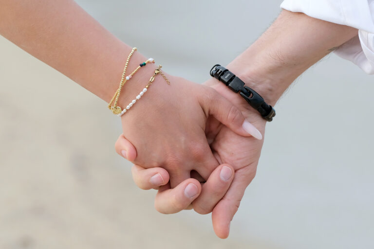 die verschlungenen Hände des Brautpaares während des Spazierganges nach der Strandhochzeit - meer sardinien urlaub