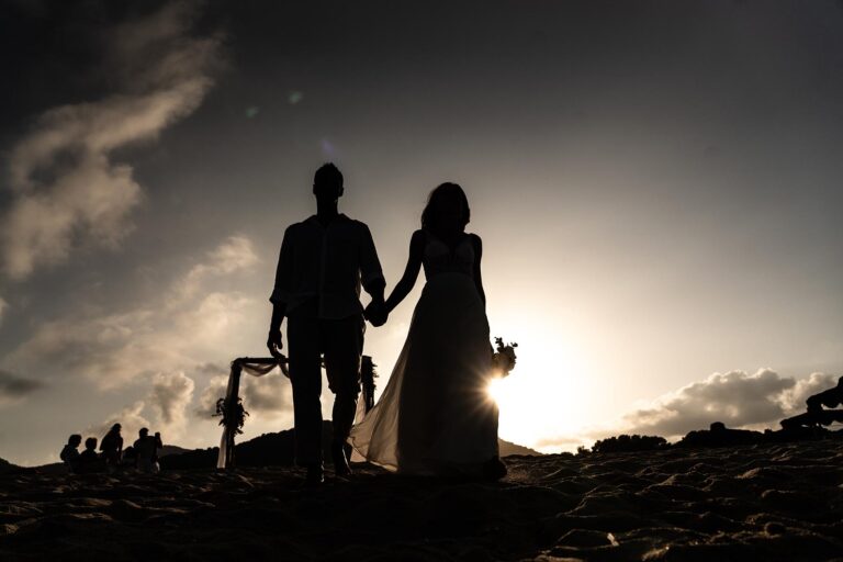 Brautpaar vor dem Trauungsbogen im Gegenlicht, Strandhochzeit - meer sardinien urlaub