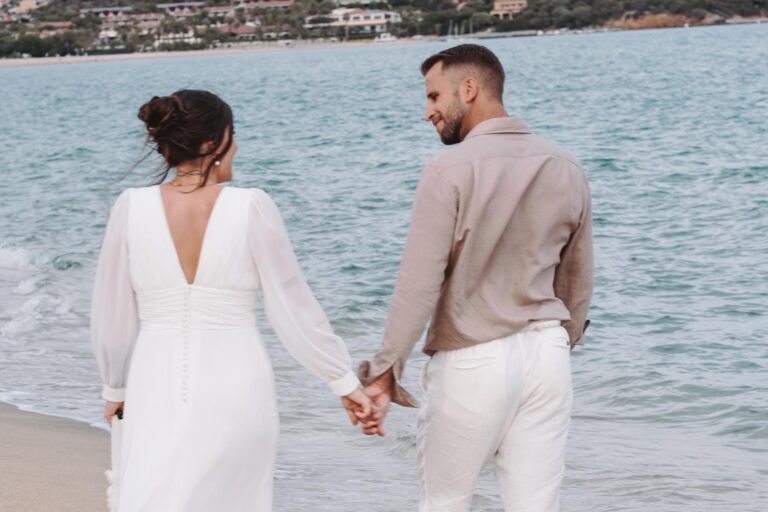 Hand in Hand spaziert das Paar am Strand entlang nach ihrer wundervollen freien Trauung - meer sardinien urlaub