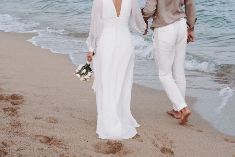 barfuss spaziert das frisch vermählte Paar im Sand, Strandhochzeit - meer sardinien urlaub