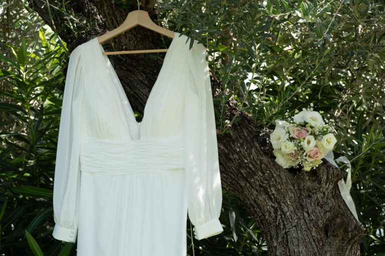 das Brautkleid hängt an einem Olivenbaum in Erwartung der Strandhochzeit - meer sardinien urlaub