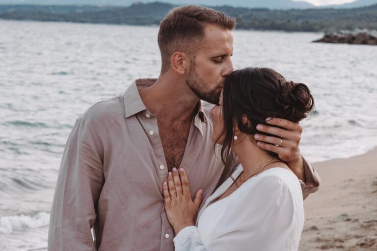 der Bräutigam küsst die Stirn seiner Ehefrau, Strandhochzeit - meer sardinien urlaub