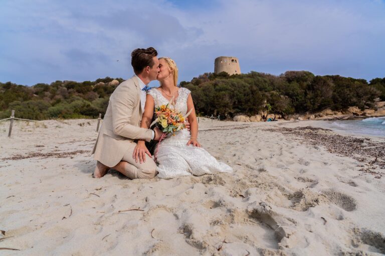 der Sarazenenturm des Strandes Cala Pira bildet die Kulisse bei diesem Paarshooting, Strandhochzeit - meer sardinien urlaub