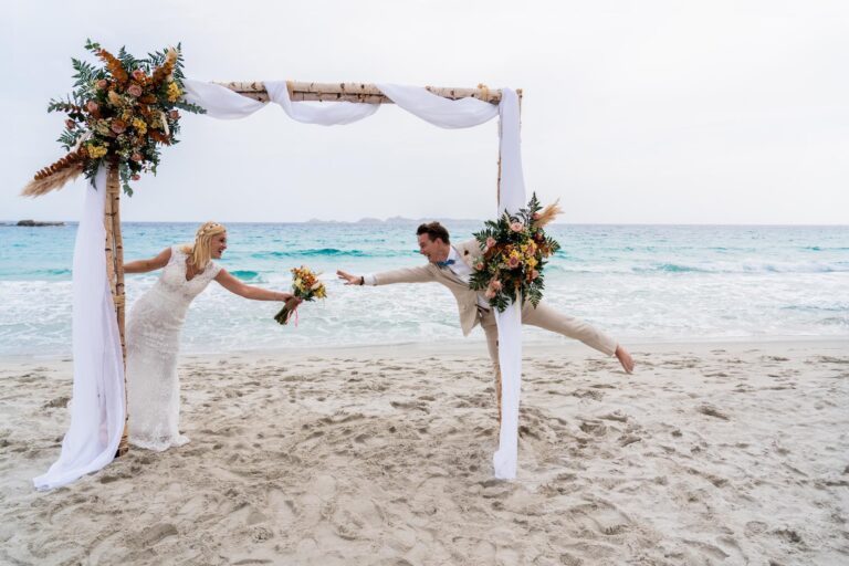 ein lustiges Paarbild am Trauungsbogen nach der Strandhochzeit - meer sardinien urlaub copia