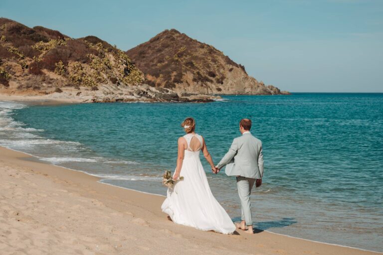 ein traumhaft romantischer Spaziergang des Brautpaares am Strand, Strandhochzeit - meer sardinien urlaub