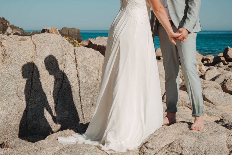 schönes Schattenspiel des Brautpaares am Granitfelsen, Strandhochzeit - meer sardinien urlaub