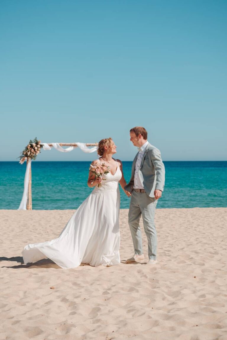 vor Glück werden im Sand kleine Tanzschritte vollzogen, Strandhochzeit - meer sardinien urlaub