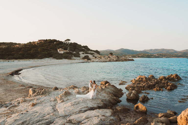 Brautpaar-an-den-Felsen-einer-Sandbucht-nach-der-Trauung-im-Standesamt---meer-sardinien-urlaub