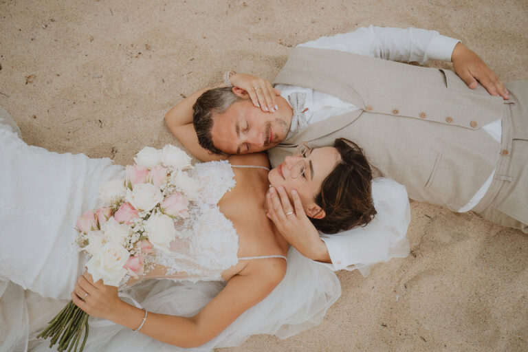 Brautpaar-liegend-am-Strand-während-des-Paarshootings,-Strandhochzeit---meer-sardinien-urlaub
