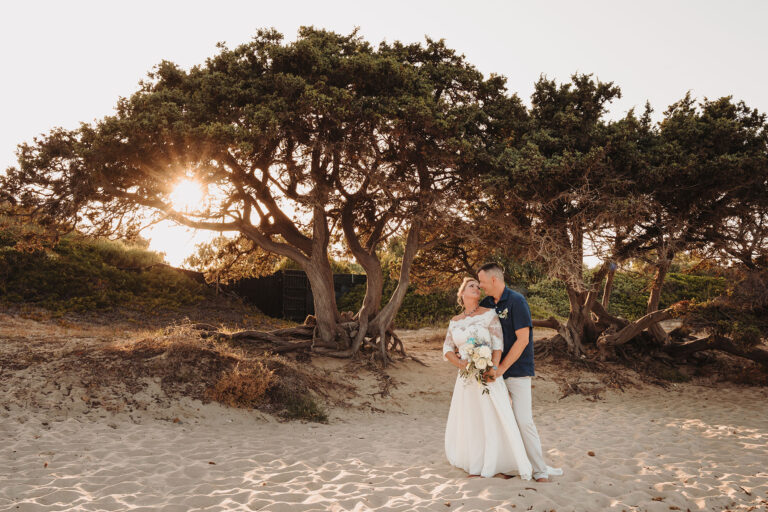 Paarshooting-im-Abendlicht-vor-knorrigem-Wacholderbaum-am-Strand,-Strandhochzeit---meer-sardinien-urlaub