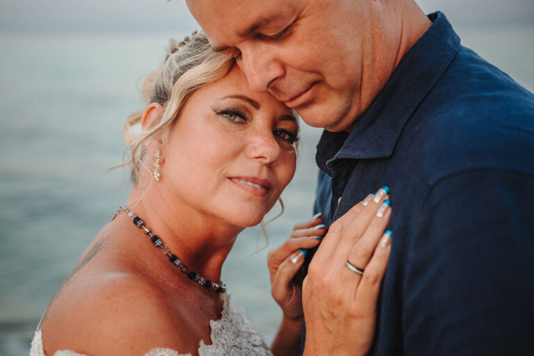 andächtig-lehnt-sich-die-Ehefrau-an-den-Ehemann,-Strandhochzeit---meer-sardinien-urlaub