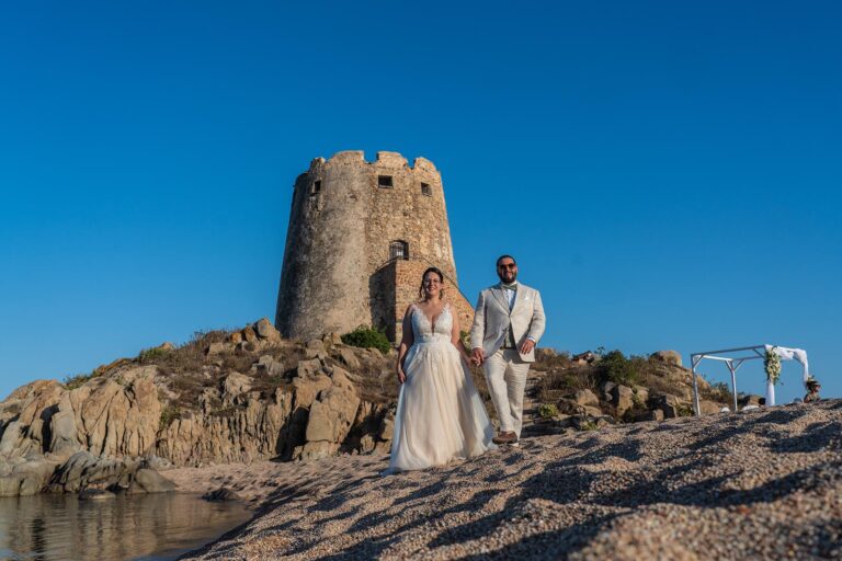 das Brautpaar Tamara und Christian auf den Felsen mit Blick zum Sarazenenturm - meer sardinien urlaub