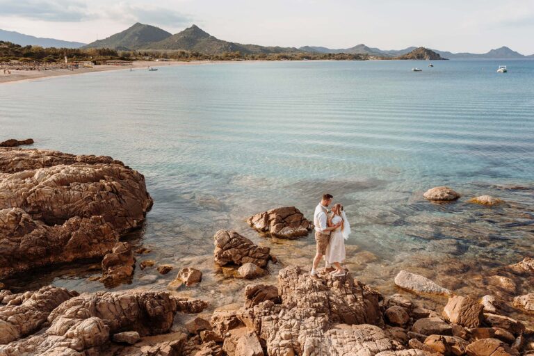 das-Brautpaar-auf-den-Felsen-vor-einem-kristallklaren-Meer,-Strandhochzeit---meer-sardinien-urlaub