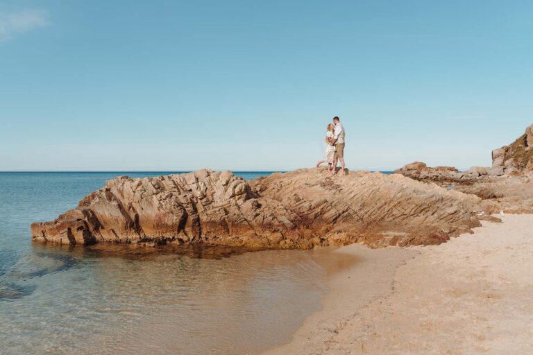 das-Brautpaar-beim-Paarshooting-auf-den-Felsen,-Strandhochzeit---meer-sardinien-urlaub