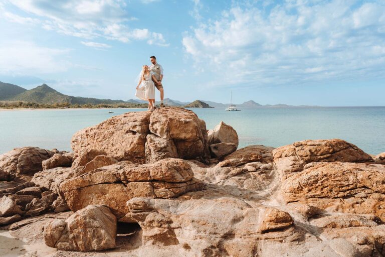 das-Brautpaar-hoch-auf-den-Felsen-vor-einem-sagenhaften-Meer,-Strandhochzeit---meer-sardinien-urlaub