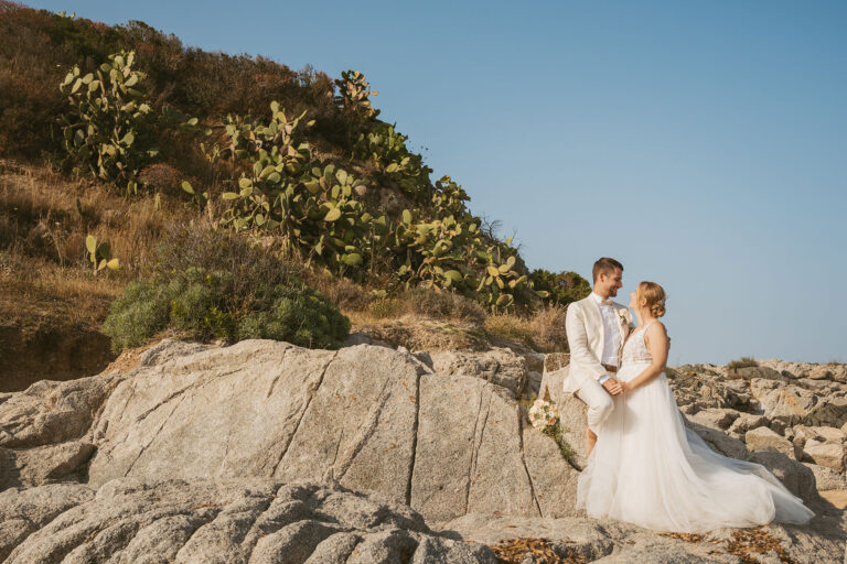das-Brautpaar-in-einer-tollen-Felslandschaft-mit-Kakteen,-Strandhochzeit---meer-sardinien-urlaub
