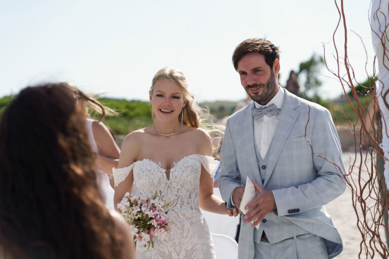 das-Brautpaar-kurz-vor-Beginn-der-stimmungsvollen-Zeremonie,-Strandhochzeit---meer-sardinien-urlaub