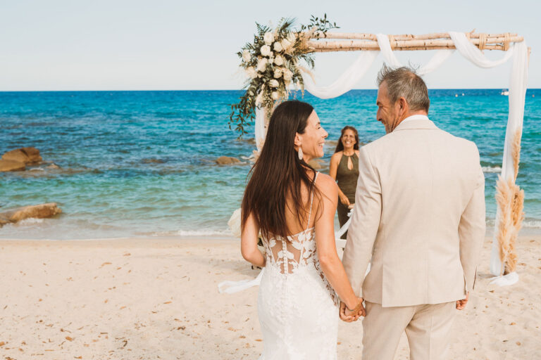 das-Brautpaar-schreitet-zur-Trauungslocation,-Strandhochzeit---meer-sardinien-urlaub