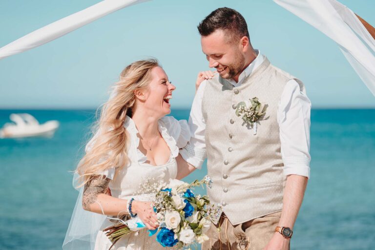das-lachende,-oberglückliche-Paar-nach-ihrer-wunderbaren-Strandhochzeit---meer-sardinien-urlaub