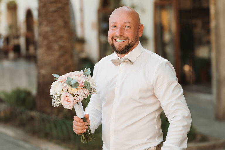 der-Bräutigam-erwartet-seine-Liebste-mit-dem-Brautstrauss-vor-dem-Rathaus,-Trauung-im-Standesamt---meer-sardinien-urlaub