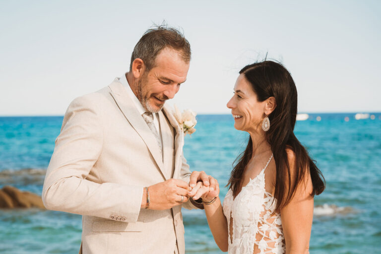 der-Bräutigam-legt-der-Braut-den-Trauring-an,-Strandhochzeit---meer-sardinien-urlaub