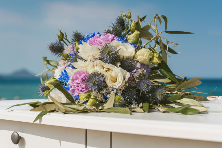 der-Brautstrauss-auf-dem-Altartisch-vor-dem-glitzernden-Meer,-Strandhochzeit---meer-sardinien-urlaub