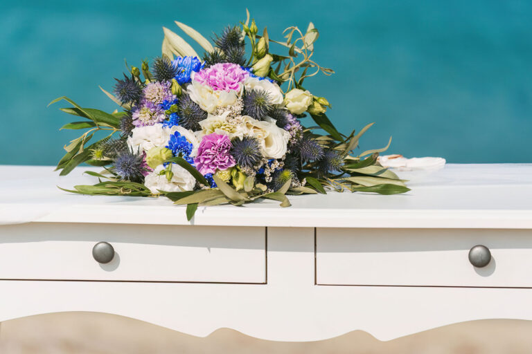 der-hübsche-Brautstrauss-auf-dem-Altartisch-vor-dem-blauen-Meer,-Strandhochzeit---meer-sardinien-urlaub