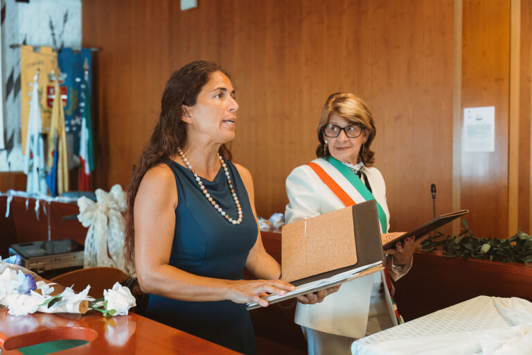 die-Übersetzerin-überträgt-die-Worte-der-Standesbeamtin-in-die-deutsche-Sprache,-Trauung-im-Standesamt---meer-sardinien-urlaub