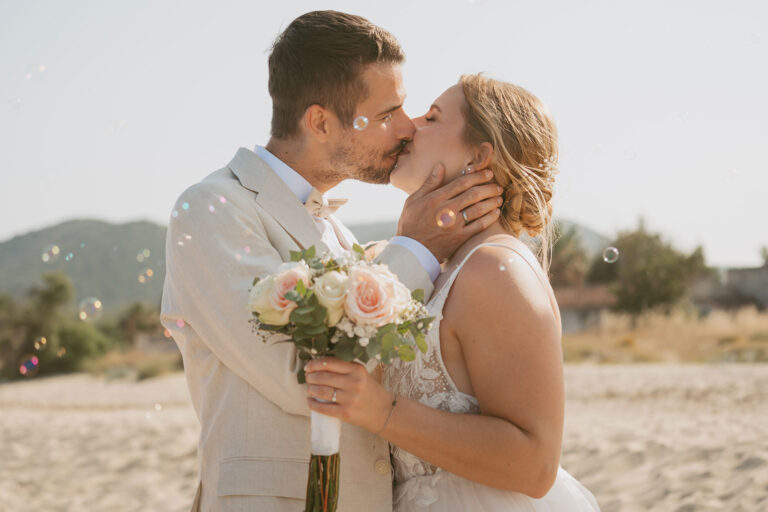 ein-liebevoller-Kuss-des-Brautpaares-nach-der-bezaubernden-Strandhochzeit---meer-sardinien-urlaub