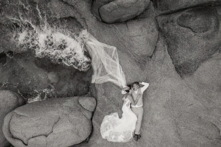 ein-wunderbares-Foto-des-auf-den-Felsen-liegenden-Brautpaares-kleiner-Welle,-Strandhochzeit---meer-sardinien-urlaub