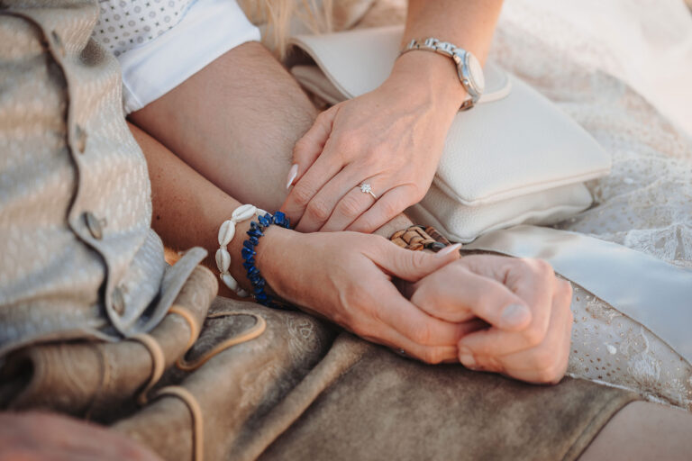 ineinander-verschlungene-Hände-während-der-Trauungszeremonie-der-Strandhochzeit---meer-sardinien-urlaub