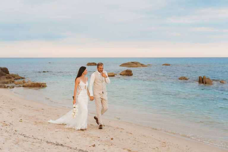 kleiner-Spaziergang-des-Brautpaares-am-Meeresufer-nach-der-Strandhochzeit---meer-sardinien-urlaub