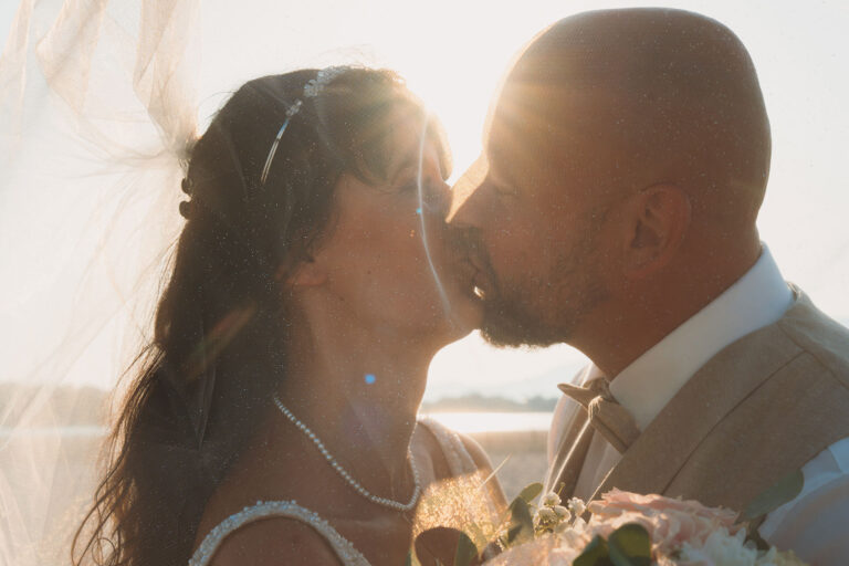 liebevoller-Kuss-des-Brautpaares-mit-Schleier,-Trauung-im-Standesamt---meer-sardinien-urlaub