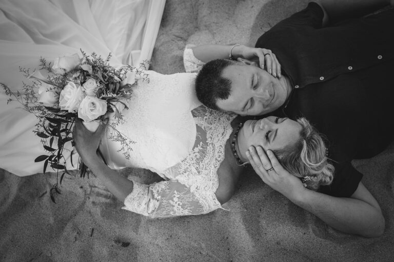 romantisches-Schwarz-Weiss-Foto-des-Brautpaares-im-Sand-nach-der-Strandhochzeit---meer-sardinien-urlaub