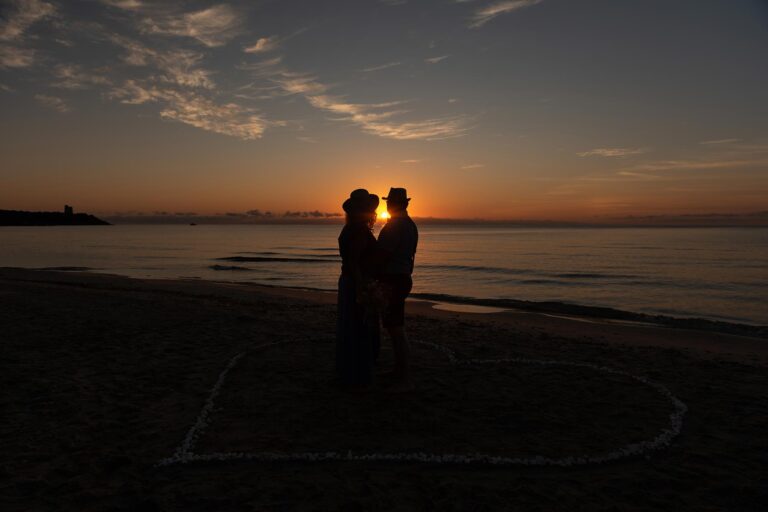 Brautpaar-blickt-in-die-aufgehende-Sonne,-Strandhochzeit---meer-sardinien-urlaub