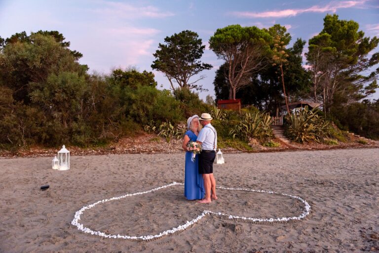 das-Brautpaar-steht-in-einem-Herz-am-Strand,-Strandhochzeit---meer-sardinien-urlaub