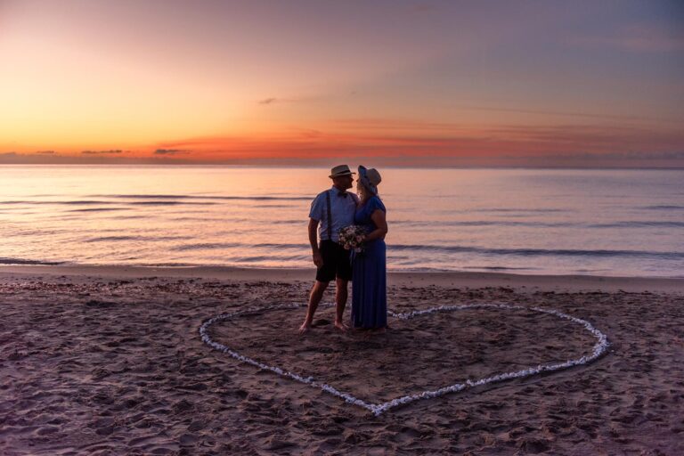 das-Brautpaar-vor-der-aufgehenden-Sonne-während-der-Strandhochzeit---meer-sardinien-urlaub