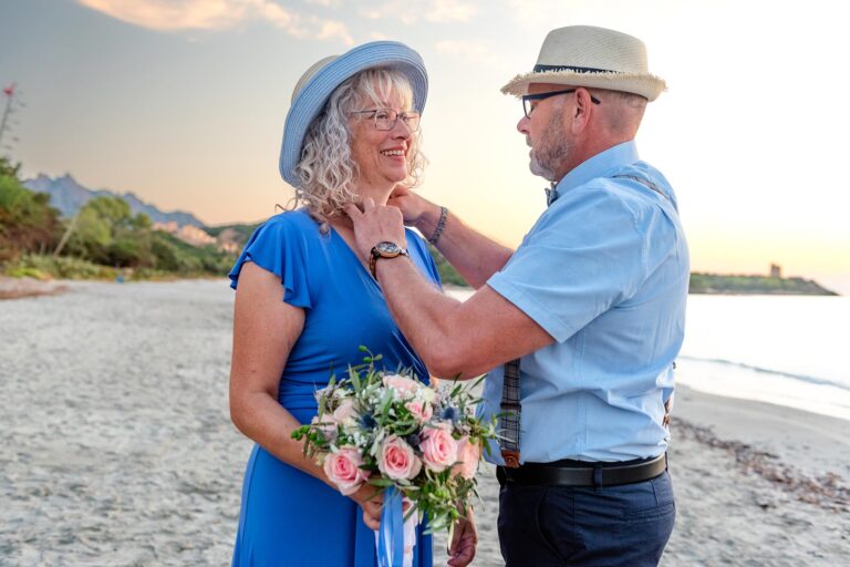 der-Bräutigam-legt-der-Braut-die-Kette-mit-dem-Trauring-an,-Strandhochzeit---meer-sardinien
