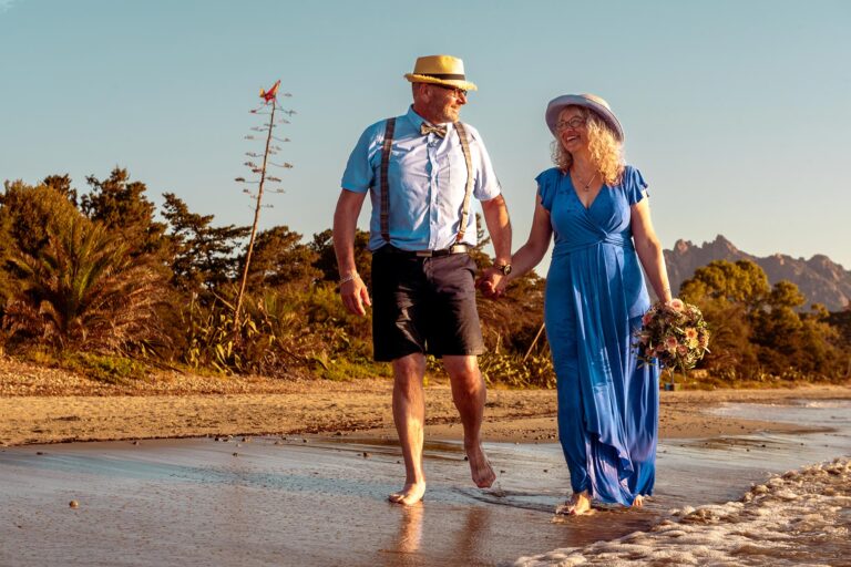 glücklich-spaziert-das-Brautpaar-am-idyllischen-Strand-nach-der-Strandhochzeit---meer-sardinien-urlaub