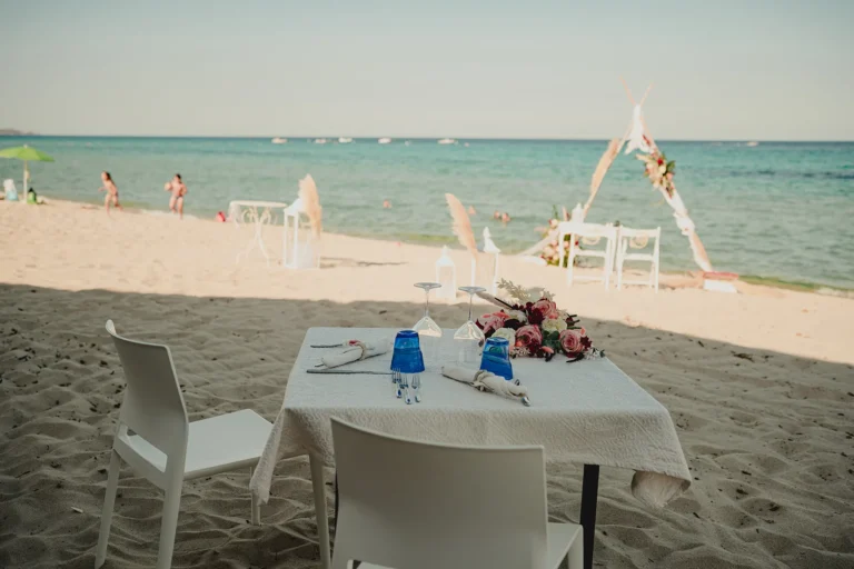 Blick vom romantischen Tisch im Sandstrand zur Trauungslocation, Strandhochzeit - meer sardinien urlaub