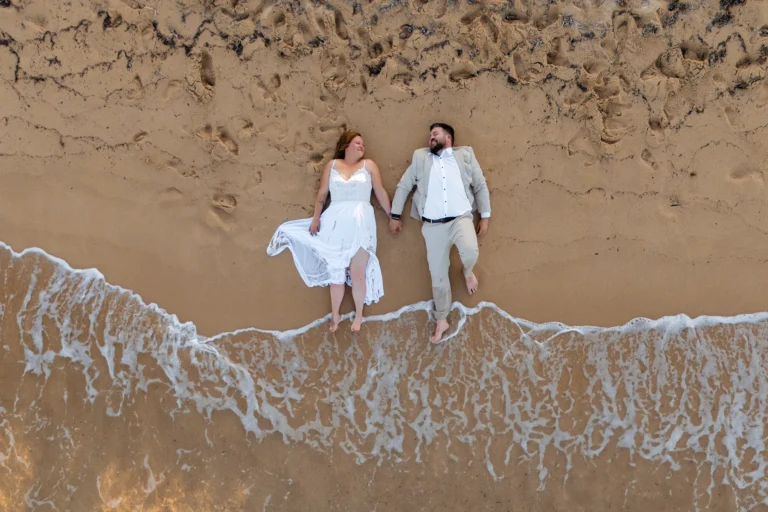 Drohnen-Aufnahme vom Brautpaar am Ufer, Strandhochzeit - meer sardinien urlaub
