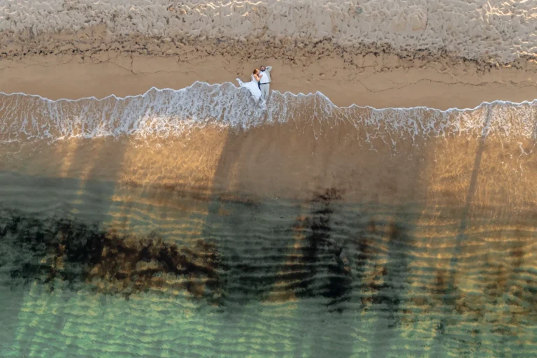 Drohnen-Foto des liegenden Paares am Ufer, Strandhochzeit - meer sardinien urlaub