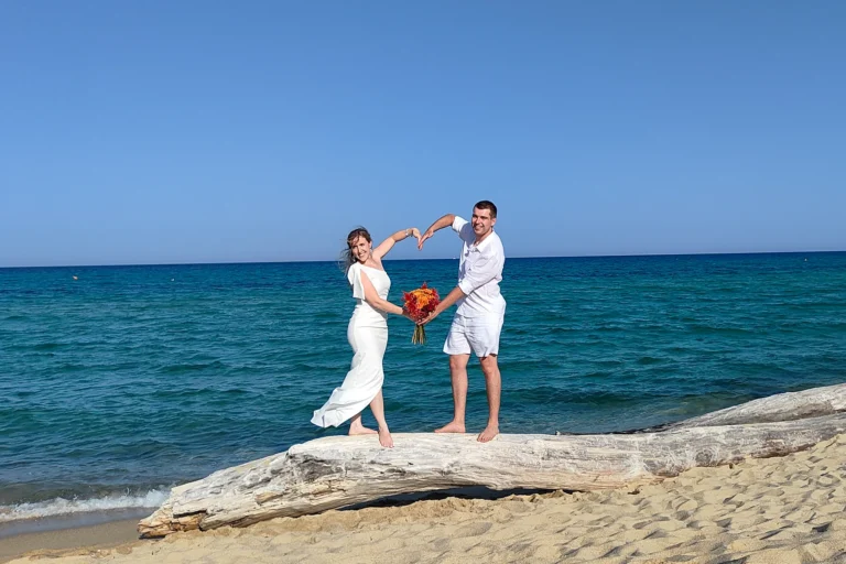 das Brautpaar formt mit den Armen ein Herz, Strandhochzeit, meer sardinien urlaub