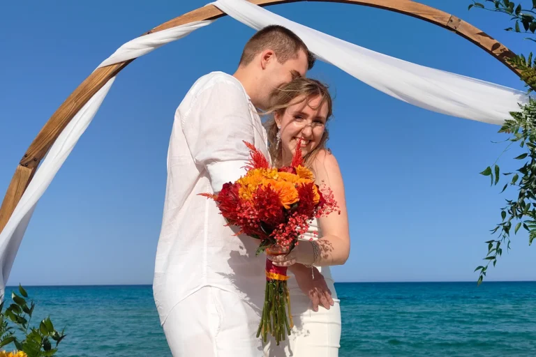 das frisch vermählte Ehepaar vor dem Traubogen, Strandhochzeit, meer sardinien urlaub
