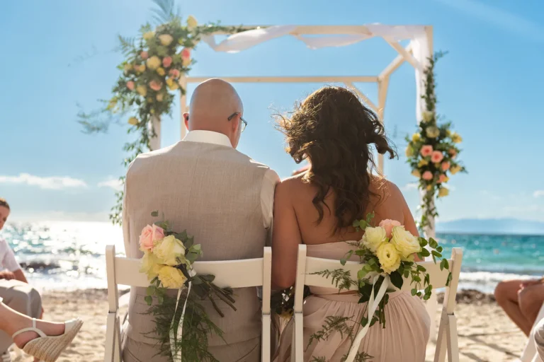 das sitzende Brautpaar vor dem Trausetting während der Strandhochzeit - meer sardinien urlaub
