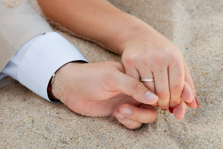 die Hände des Brautpaare im Sand, Strandhochzeit - meer sardinien urlaub